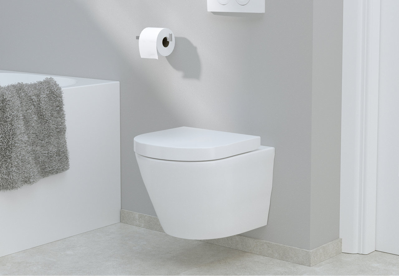 Une petite toilette suspendue blanche dans une salle de bain aux murs gris clairs, avec papier toilette et serviette grise. Un modèle compact de x²o badkamers.