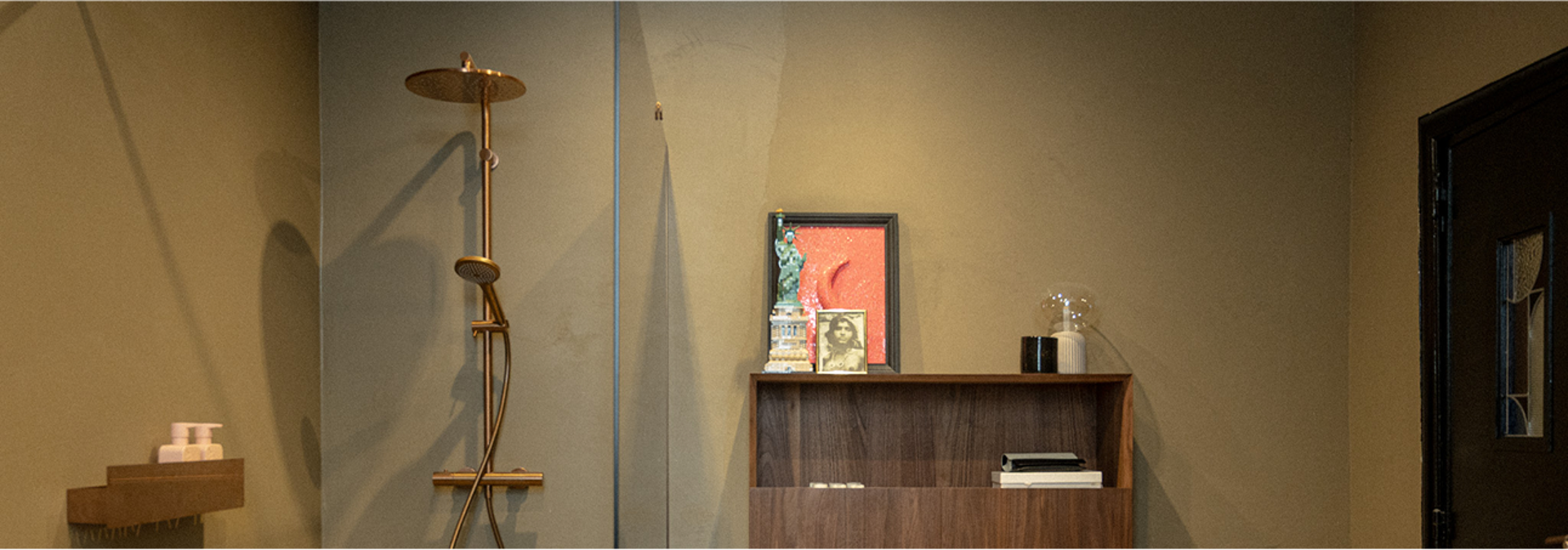Inloopdouche met regendouche en houten kastje met persoonlijke decoratie.