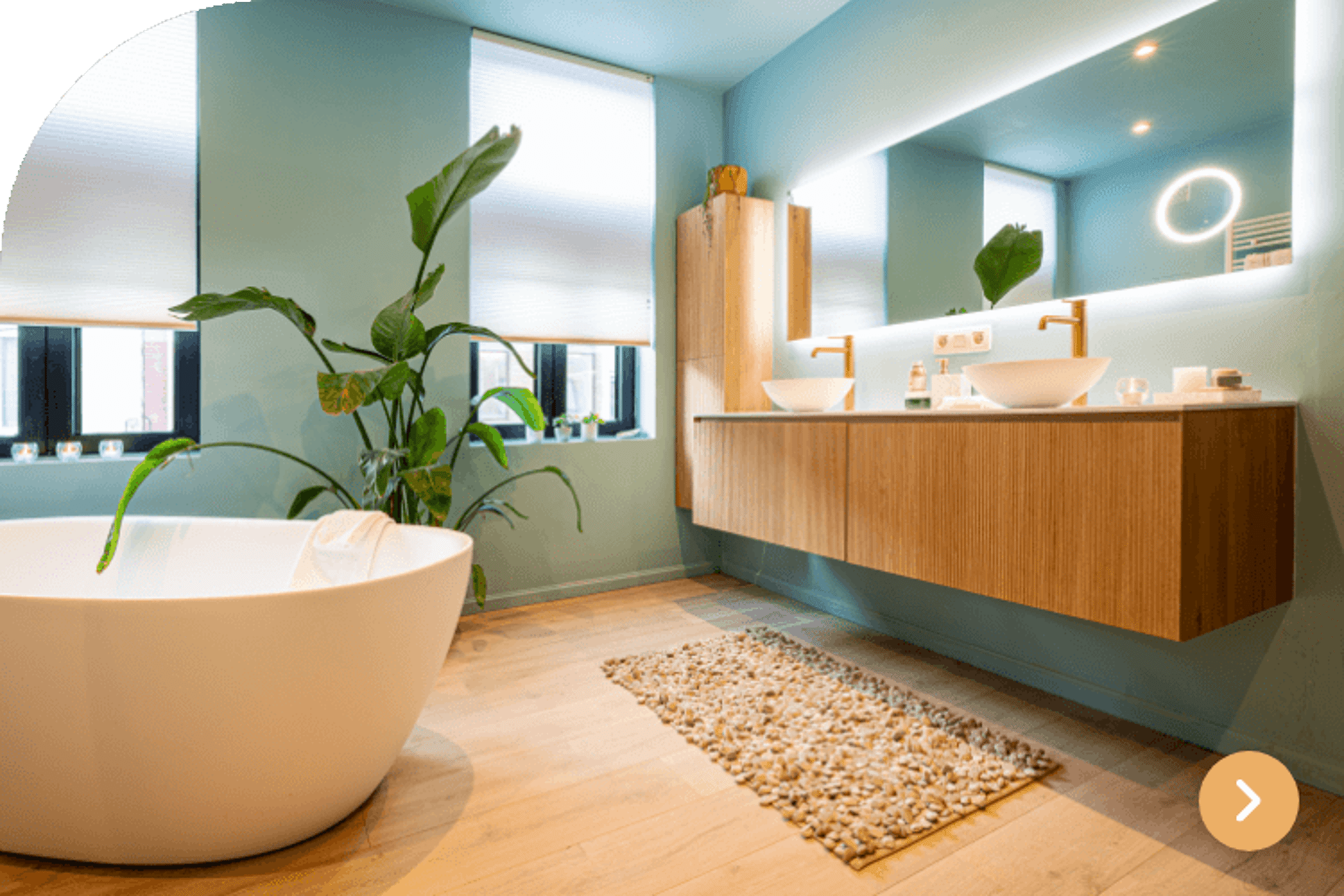 Badkamer in blauwe tinten met vrijstaand bad, dubbele wastafel en houten accenten