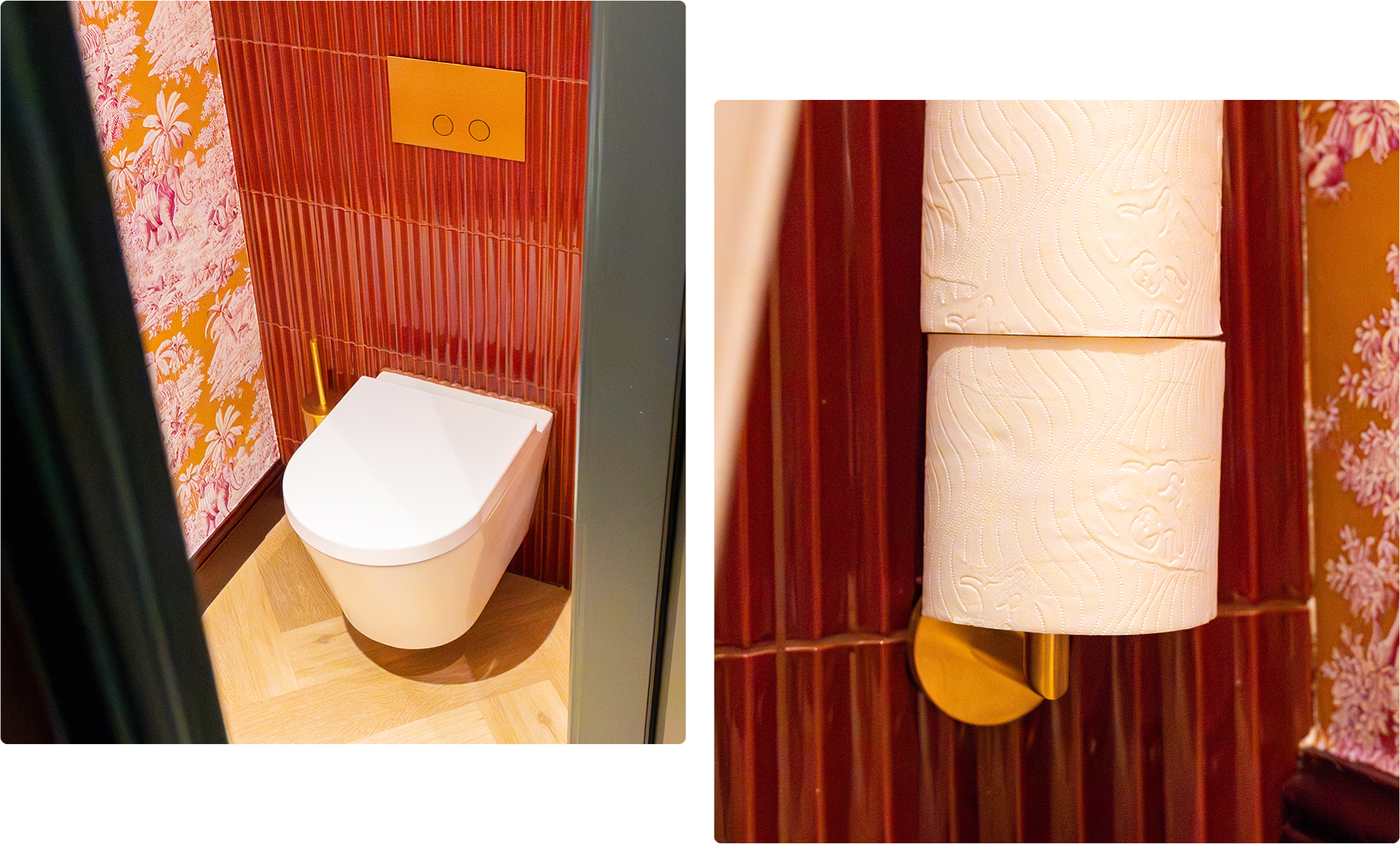 Een wit hangtoilet van x²o badkamers tegen een wand met verticale rode tegels en oranje-roze behang met tropische motieven, gecombineerd met een goudkleurige toiletborstel en een inbouwbedieningspaneel.