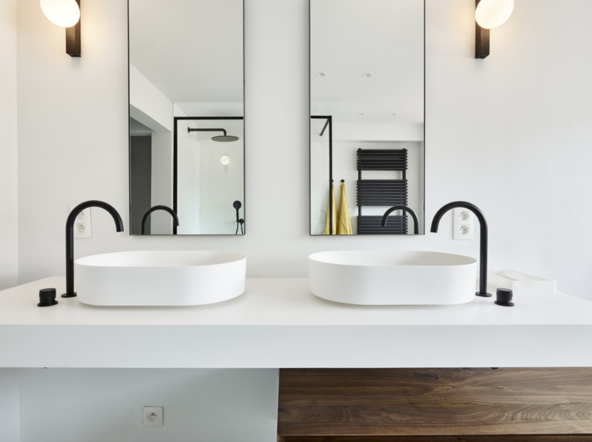 Geräumiges Badezimmer mit Badewanne, Glasduschwand und schwarzen Akzenten.