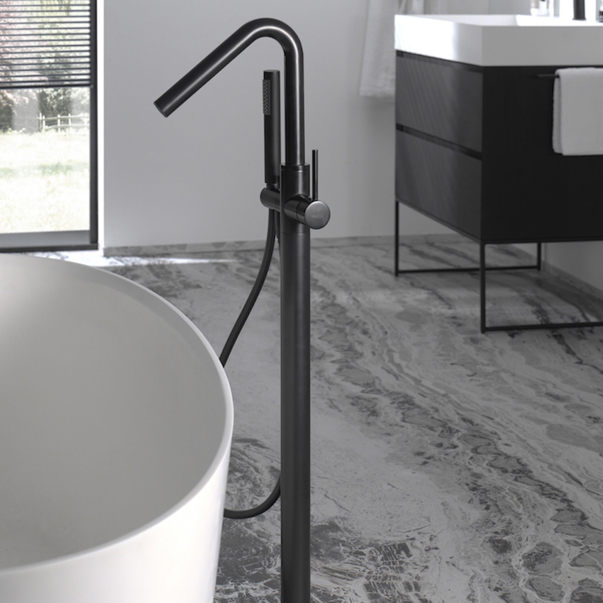 Freistehende schwarze Badarmatur mit Handbrause neben einer modernen weißen Badewanne, stilvolles Design.