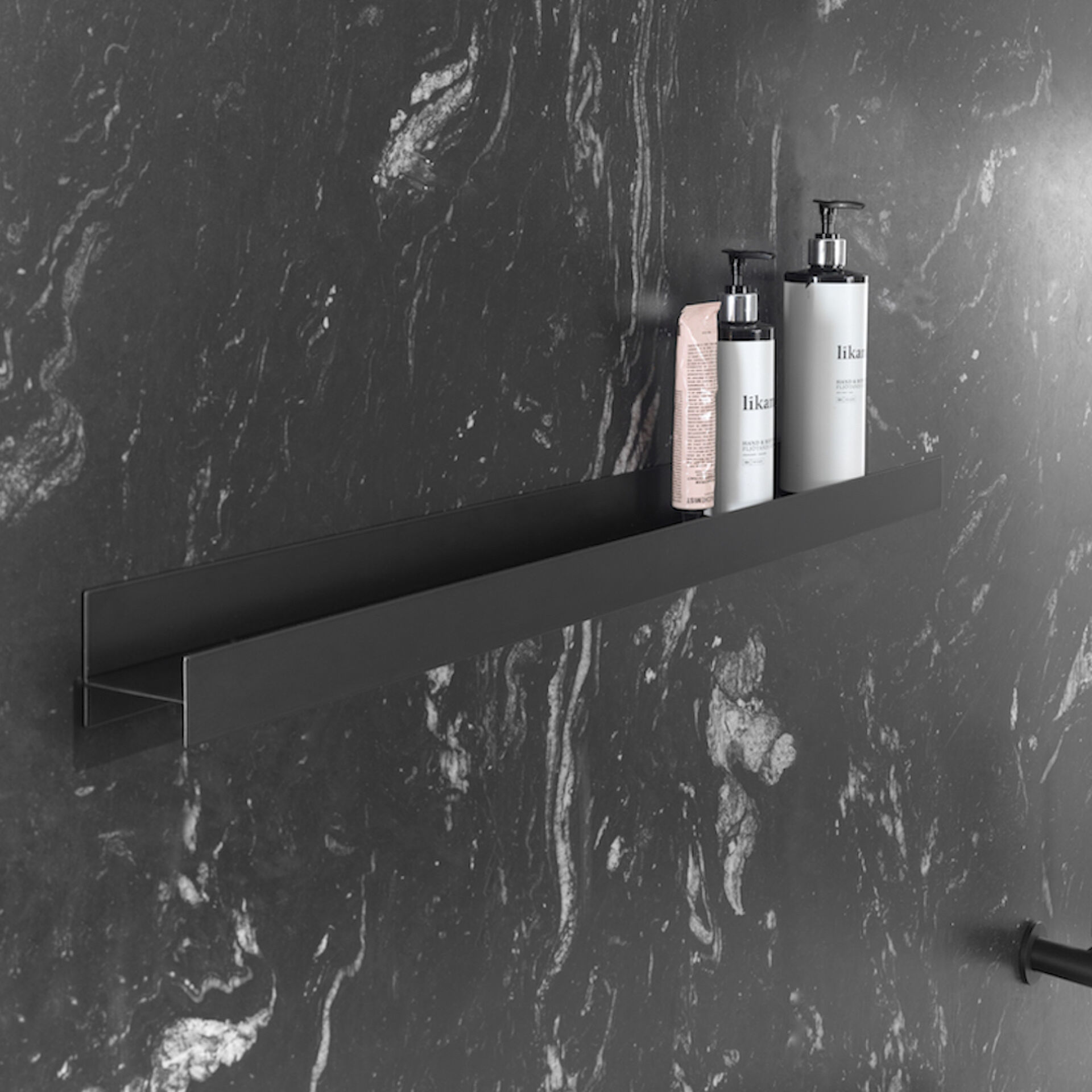 Étagère murale en métal noir sur mur en marbre, design minimaliste et fonctionnel pour les produits de bain.