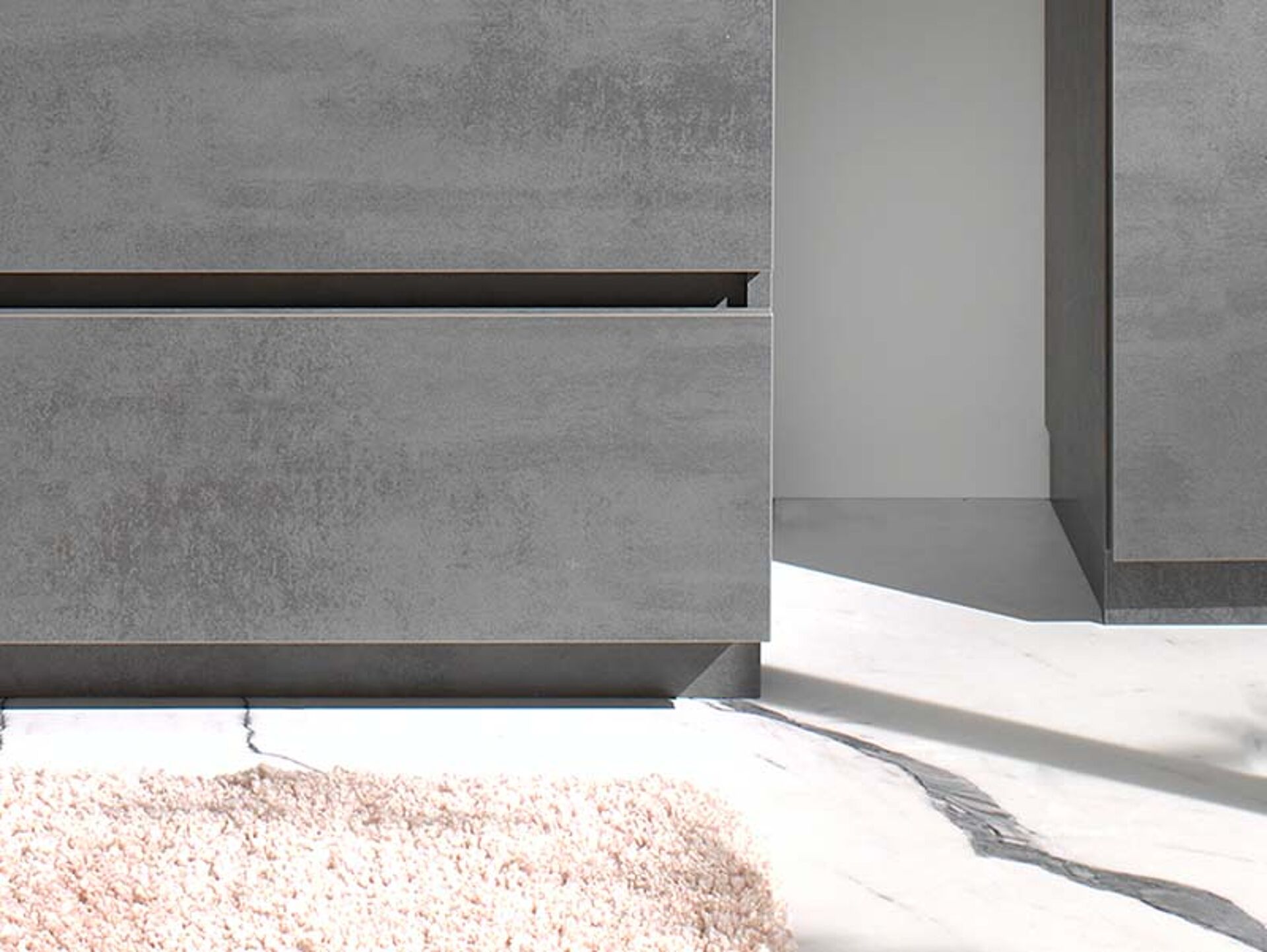 Modernes Badezimmermöbel mit grauen Schubladen, minimalistisches Design und glatte Oberfläche auf Marmor.