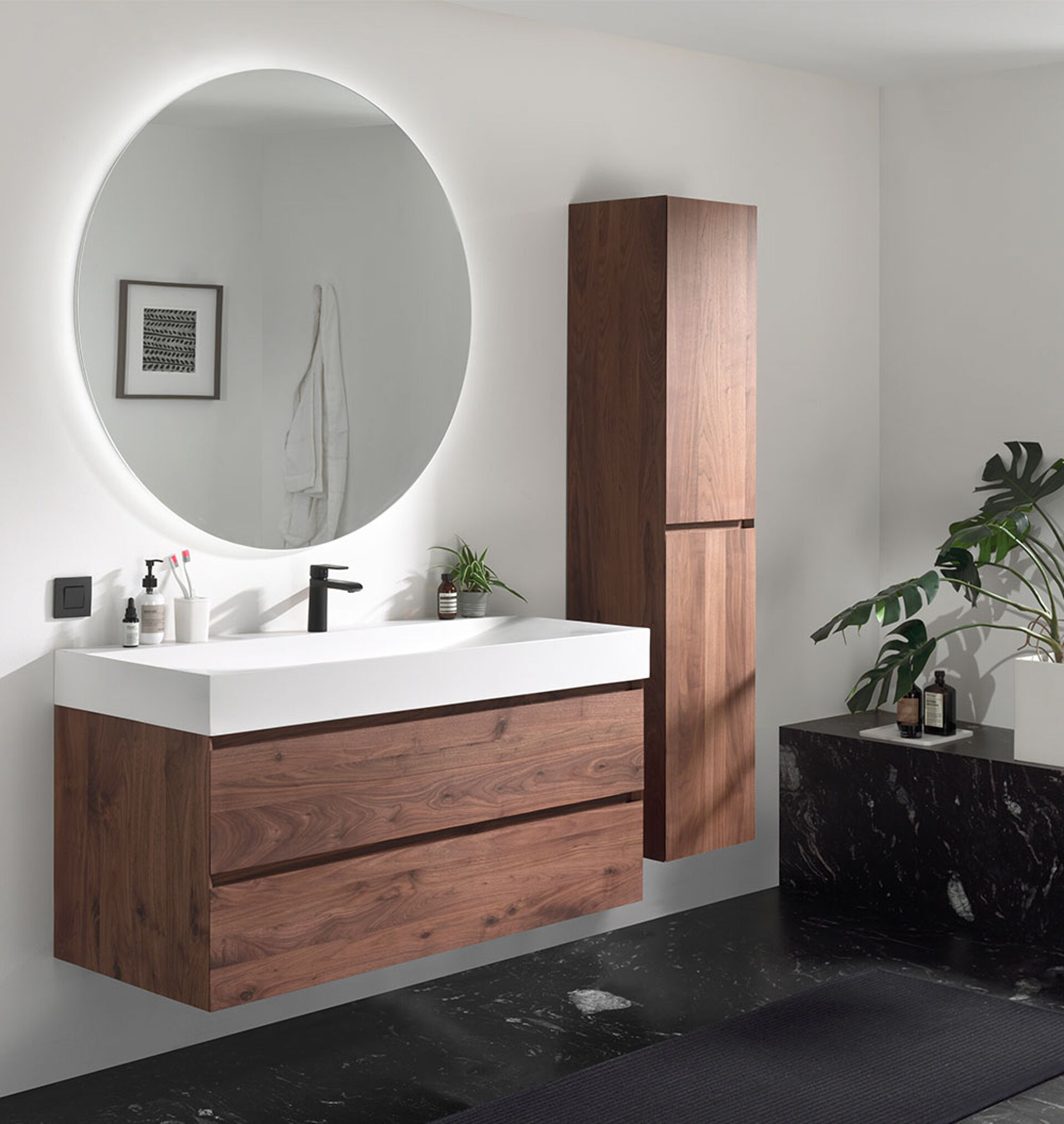 Salle de bain moderne avec meuble lavabo en bois, miroir rond, robinets noirs et accents en marbre.