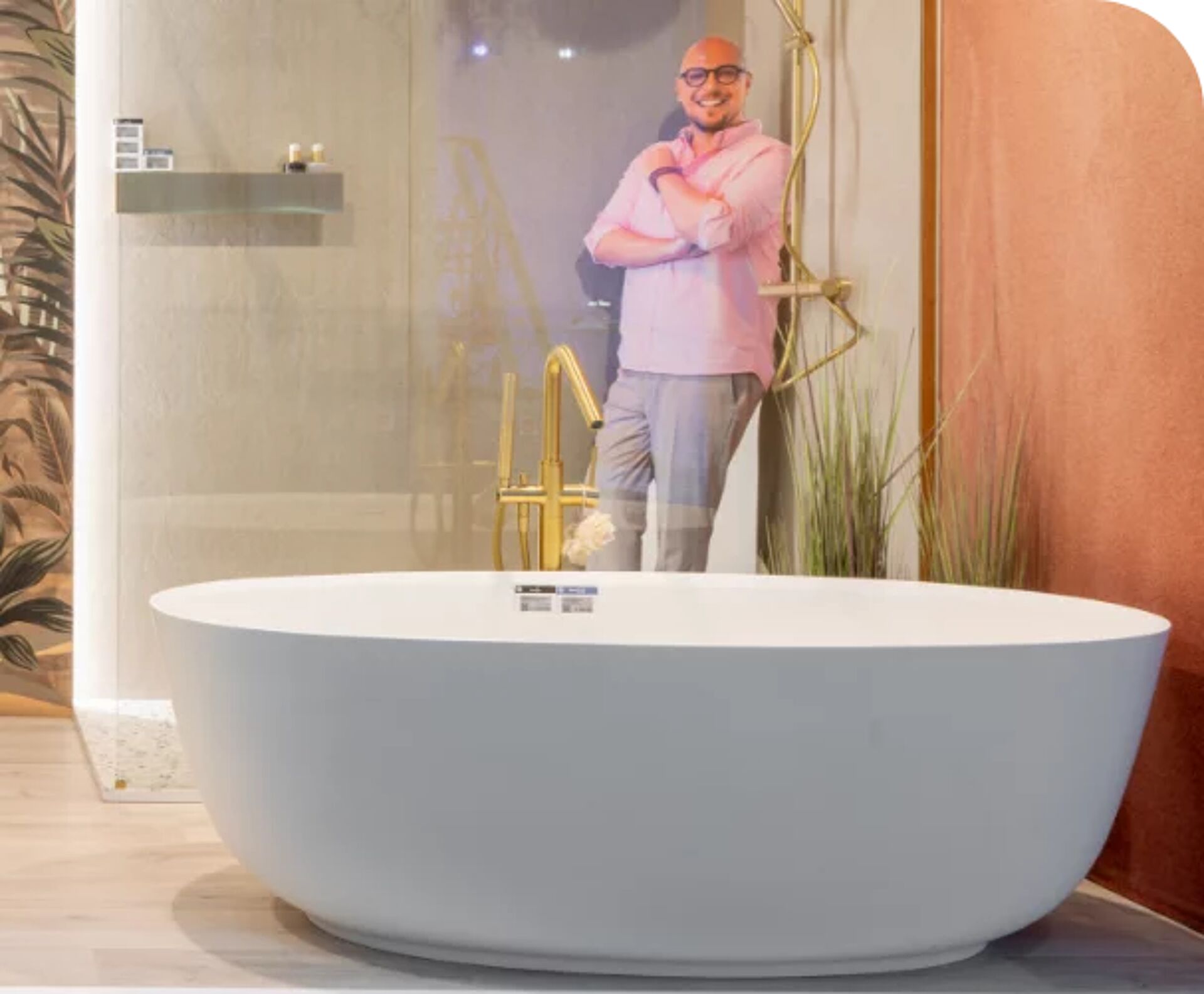 Luxe badkamer met vrijstaand bad, gouden douchekranen en afbeelding van een persoon