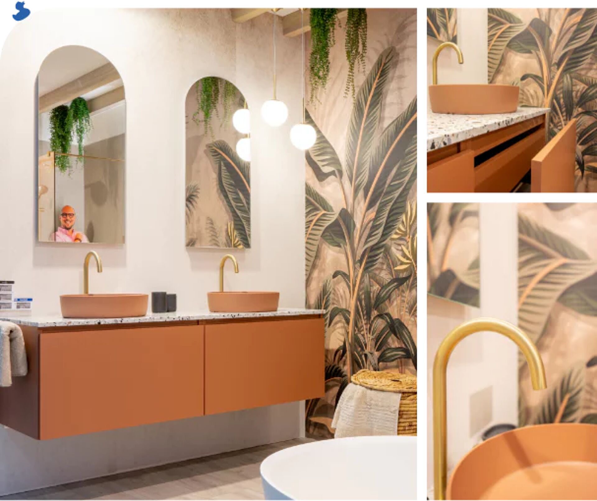 Moderne badkamer met dubbele wastafel, gouden kranen, terrazzo blad, tropisch wandtapijt en spiegels