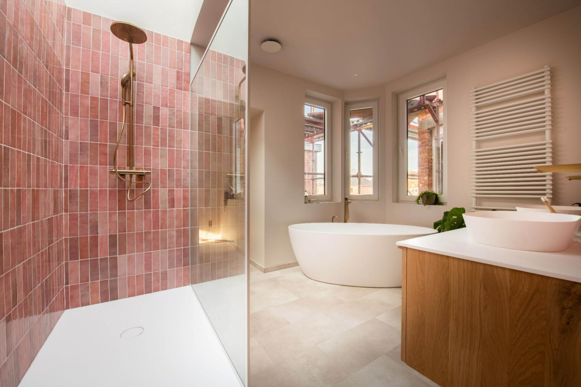 Moderne badkamer met inloopdouche, vrijstaand bad, houten wastafelmeubel en handdoekradiator