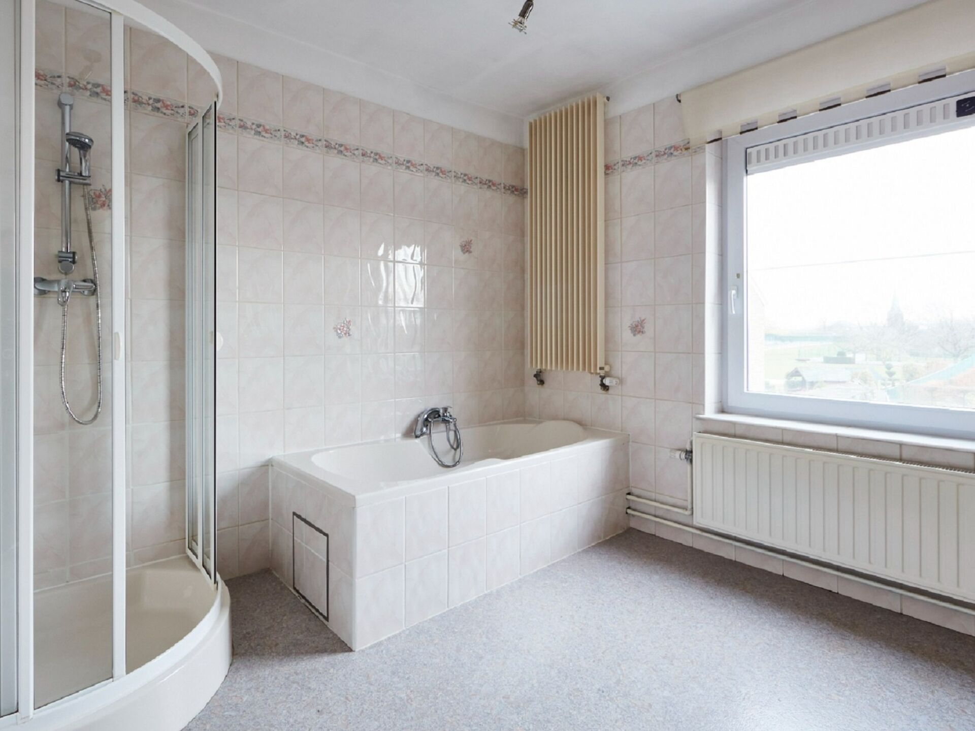 Badezimmer mit Duschkabine und Badewanne, Fenster mit Aussicht.
