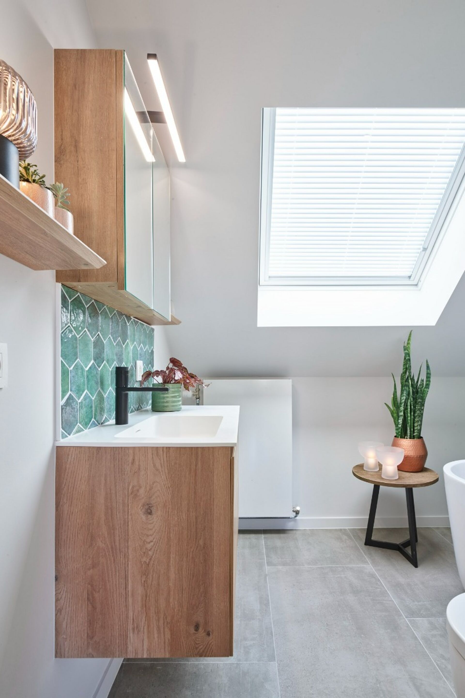 Moderne Badezimmer mit Holzschrank, grünen hexagonalen Fliesen und Dachfenster.