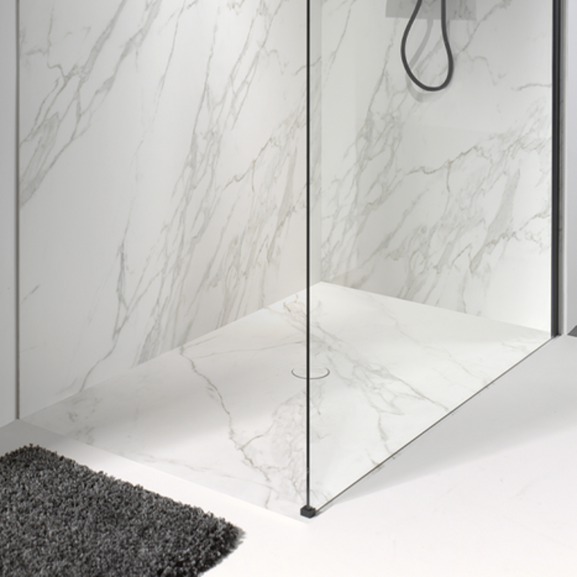 Moderne inloopdouche met marmeren tegels en glazen wand.