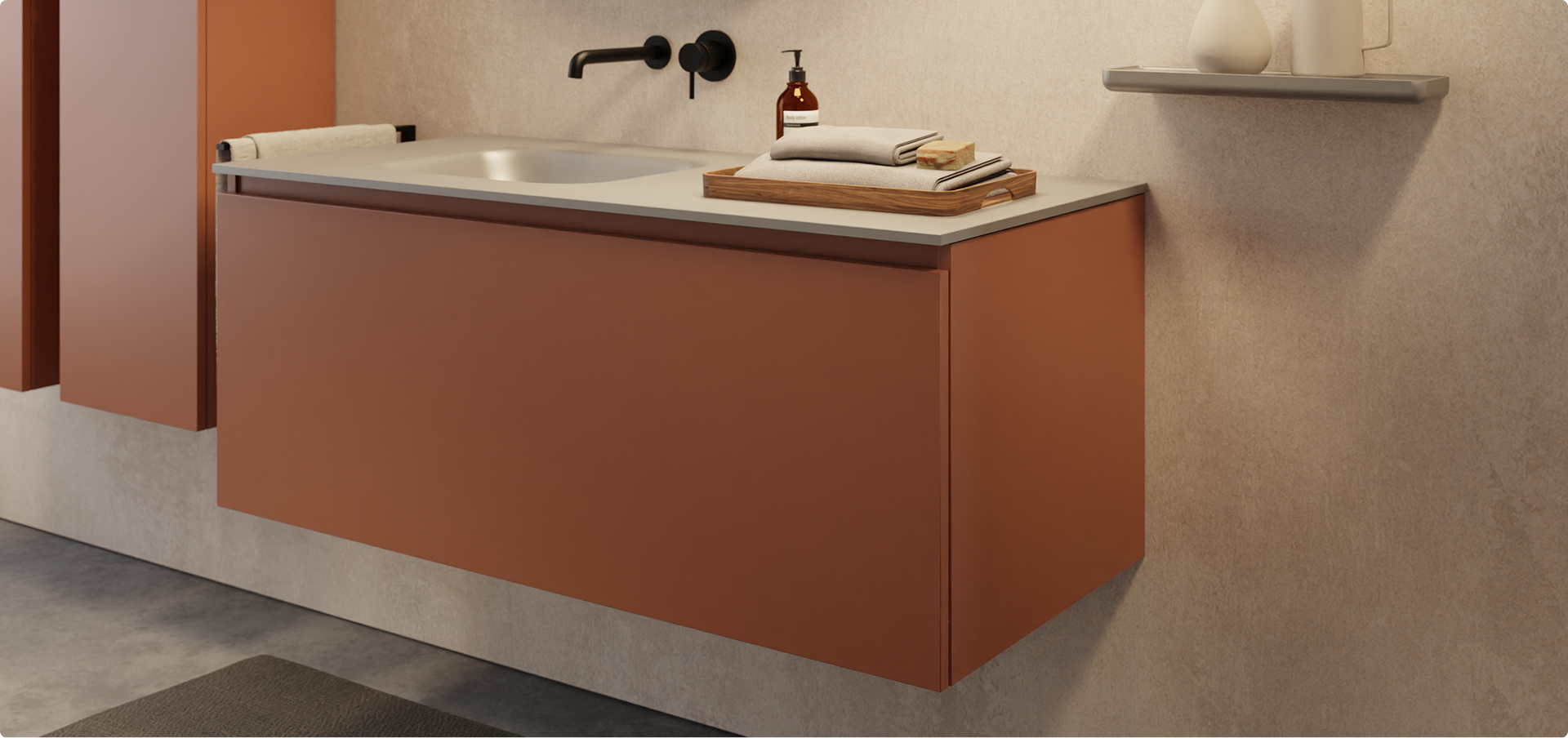  Warme x²o badkamers sfeer met een zwevend roestkleurig badkamermeubel, matzwarte kraan en ronde spiegel met zwarte rand. De beige wand en accessoires zoals het houten dienblad en keramiek op het wandplankje brengen een aardse, rustgevende uitstraling.